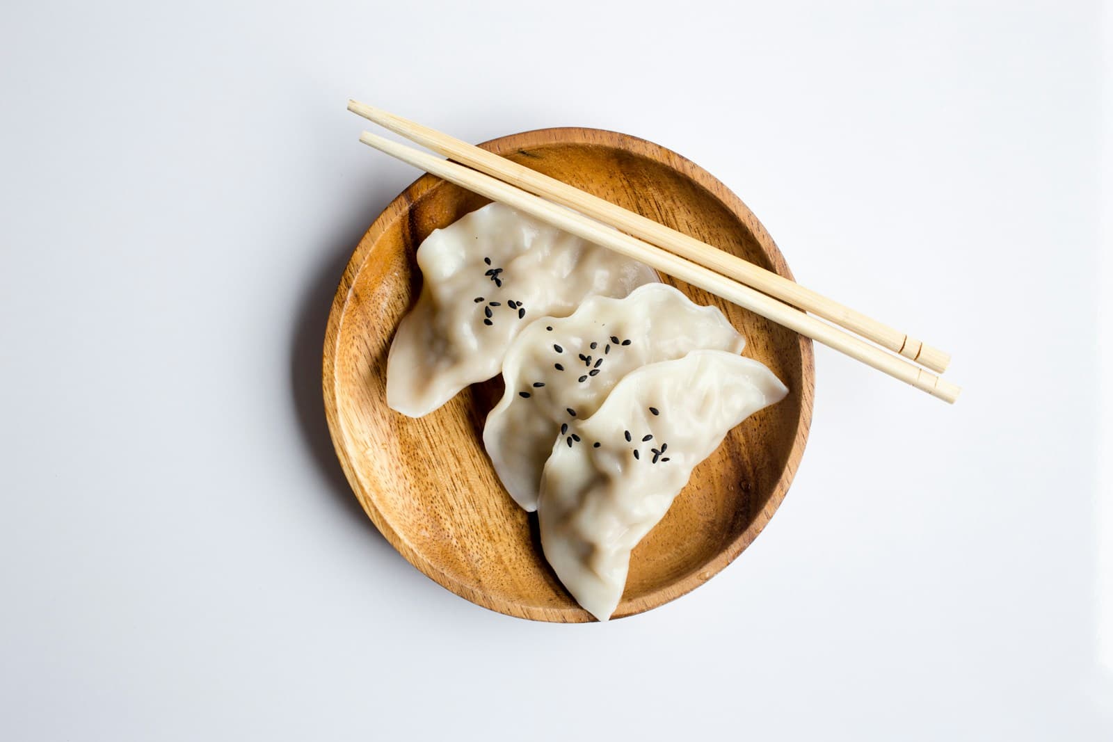 Dumplings and chopsticks on a wooden plate
